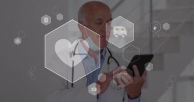 Kıdemli doktor tableti tıklatıyor ve hasta verilerini incelerken kalp ritmi altıgen simgelerini ortaya çıkarıyor. Tıbbi, teknoloji, yenilik, sağlık, teşhis, fütüristik, profesyonel