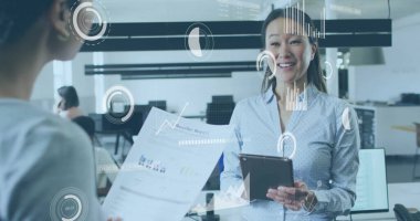 Tablet işkadını yazılı rapor ve veri örtüleriyle ofiste çizelgeleri tartışıyor. İşbirliği, takım çalışması, teknoloji, ilerleme, iletişim, şirket, yenilik