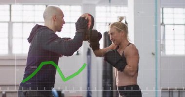 Koç odaklanma eldiveni, stajyer boks kombinasyonlarını yeşil performans grafiği altında çalıştırıyor. Antrenman, fitness, dövüş sanatları, egzersiz, güç, atlet, hareket