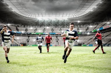 Çok ırklı rugby oyuncularından oluşan iki takım bir spor stadyumunda rugby oynuyor.