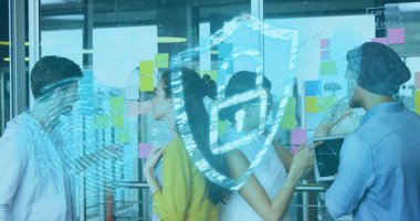 Collaborating team analyzing sticky notes on glass wall in office, with tablet and shield icon. Collaboration, innovation, brainstorming, technology, cybersecurity, workspace, digital