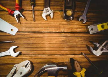 Assorted hand tools are lying on flat wooden tabletop in flat design, showing pliers and wrenches. Hardware, craftsmanship, precision, engineering, diy, workshop, maintenance