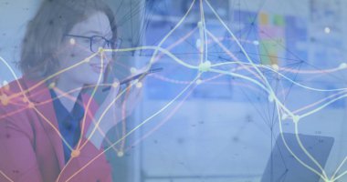 Konuşan kırmızı ceketli müdür elinde akıllı telefon, ofiste bilgisayara bakıyor ve verileri kopyalıyor. Profesyonel, çalışma alanı, modern, analitik, iletişim, dijital, kurumsal