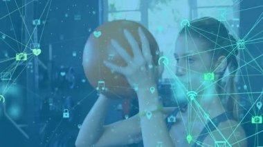 Bir kadın göğsüne tıp topu yerleştiriyor ve dijital kaplamayla uyum sağlamak için üzerini bastırıyor. Güç, egzersiz, dijital teknoloji, modern, sağlık, kardiyo, eğitim