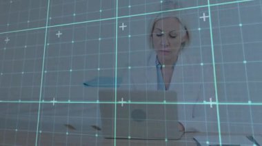 Olgun bir ofis çalışanı, bilgisayarını deniz mavisi kaplamalı inceleyip akıllı telefonlara cevap veriyor ve çalışıyor. Profesyonel, üretkenlik, teknoloji, iletişim, çalışma alanı, modern, odaklanmış