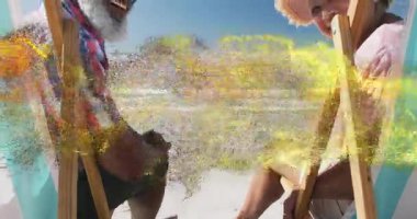 Plaj koltuklarına yaslanan çiftleri gösteren bir seyahat reklamı. Altın parçacıklar gülümsemeyi çağrıştırıyor. Plaj, rahatlama, neşe, uyum, dinginlik, doğal, sıcak