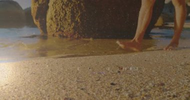 Erkek ziyaretçi, yosunlu kayaların üzerinde çıplak ayakla sörf yapıyor. Yolculuk için dalgalar ve ayak izleri bırakıyor. Deniz kıyısı, sükunet, minimalist, doğa, yansıma, macera, sükunet