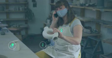 Potter seramik stüdyosunda dönen kil kap akıllı telefondan konuşuyor ve ekolojik etkiyi görselleştiriyor. El sanatları, sürdürülebilirlik, yenilik, çevre dostu, yaratıcı, tasarım, çevre