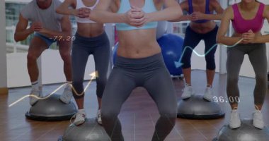 Grup olarak BOSU 'ya giriyoruz. Kaplamayı başlatıp çömelme hareketleri yapıyoruz. Sonra da zemin izleme verilerini alıyoruz. Grup egzersizi, denge eğitimi, dijital arayüz, yüksek katlı spor salonu, senkronize hareket, fonksiyonel zindelik, modern sağlık