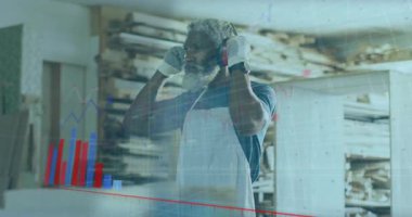 Erkek marangoz kulaklık kaldırıyor veri tabletini alıp veri analizi yapıyor. Atölye, işçilik, güvenlik, teknoloji, analiz, endüstri, üretkenlik