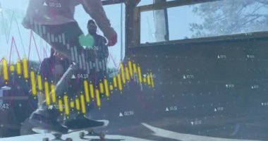 Kaykaycı rampadan iniyor, arkadaşları finans haritalarını izlerken iniş numaraları yapıyor. Extreme sporları, serbest stil, şehir eğlencesi, adrenalin, gençlik kültürü, dinamik, açık hava