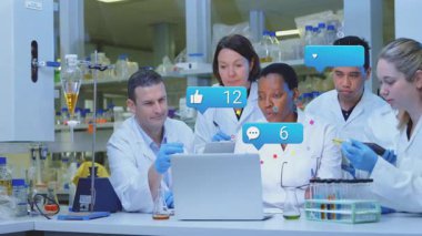 Pipet tutan bilim adamı dizüstü bilgisayara bakıyor. Sevgi ve yorumları canlandırıyor ve teknolojik taahhüdü artırıyor. Araştırma, yenilik, biyoteknoloji, işbirliği, analitik, bilim, ilerleme