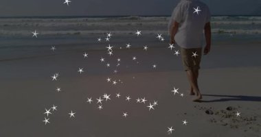 Orta yaşlı bir adam çerçeveye giriyor, kumda yürüyor ve arkasında dönen kıvılcımlar yaratıyor. Doğa, sükunet, sihir, fantezi, macera, minimalizm, ışıltı