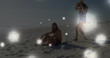 Elinde hasır şapka tutan kadın, sahilde seyahat için güneş gözlüğü takan bir adamla denge kuruyor. Deniz kenarı, boş, neşeli, kaygısız, açık hava, retro, canlı