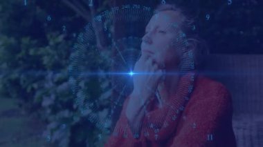 Hasır sandalyedeki kadının üzerinde dijital arayüz beliriyor çenesini dinlendirip nabız veri örtüsünü analiz ediyor. Gelecekçi, düşünceli, teknoloji, doğa, rahatlama, yenilik, huzur