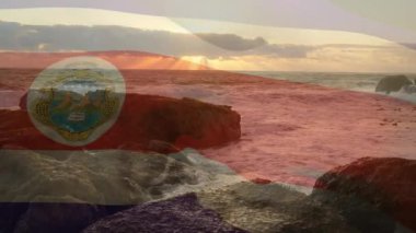 Kosta Rika bayrağını dalgalandıran güneş, kıyı markalaşması için dalgalanan okyanus dalgalarıyla kayboluyor. Deniz manzarası, kıyı şeridi, okyanus, günbatımı, bayrak, sükunet, doğal