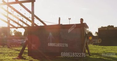 Erkek sporcu engelli parkurun yanında koşuyor veri örtüşmelerini gösteriyor, antrenman için atlıyor. Sporcu, dayanıklılık, çeviklik, açık hava, eğitim, dinamik, fitness