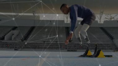 Genç koşucu başlangıç bloklarına adım atıyor ve hızlı fırlatma için protez bıçakları ayarlıyor. Sporcu, performans, hız, eğitim, güç, yenilik, modern