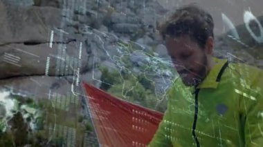 Orta yaşlı bir adam hamakta oturmuş cihaza veri yüklüyor ve titreşimli dünya haritasıyla rahatlıyor. Açık hava, rahatlama, teknoloji, macera, refah, dijital, manzara