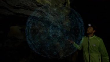 Araştırmacı mağarada el kaldırıyor ve teknoloji için mağara duvarını haritalamak için 3 boyutlu hologram küresini etkinleştiriyor. Jeoloji, keşif, yenilik, görselleştirme, bilim kurgu, macera, bağlantı
