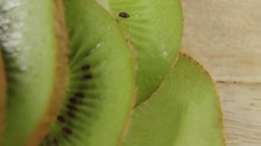 Ekranda görünmeyen alevler kivi dilimlerini süpürüyor ve dinamik röfleler ekliyor. Meyve, taze, canlı, doğal, sağlıklı, aşçılık, tasarım