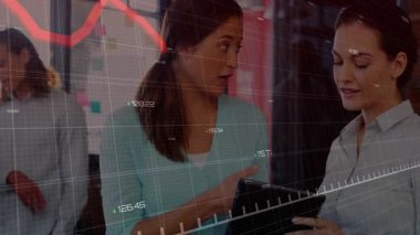 Modern ofiste tableti tıklatan kadın meslektaşlar veri analizi için hareket eden kırmızı çizgi grafiğini ateşliyor. İşbirliği, takım çalışması, analitik, dijital, iletişim, yenilik, modernite