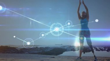 Kıdemli yogi kayalık kıyılarda kol kaldırıyor, protez bacağı kaplayan sağlık ağını etkinleştiriyor. Sağlık, esneklik, bağlantı, açık hava, farkındalık, canlılık, maneviyat