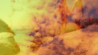 İki kız kayaya basıyor kollarını denize doğru kaldırıyor ve bulutlar sürükleniyor. Macera, keşif, arkadaşlık, birlik, sükunet, manzara, doğal