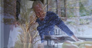 Mavi süveter ve bluz giyen, mutfak tezgahını ağaç dallarıyla harmanlayan zayıf bir çift. İç gözlem, uyum, bağlantı, dinginlik, doğal ışık, minimalizm, doğadan esinlenilmiş