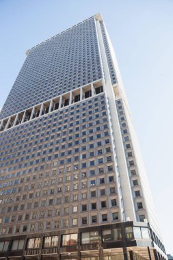 Yüksek katlı ofis kulesi yansıtıcı camlar, pencereler ve tepe örtüsüyle düz bir resimde yükseliyor. Gökdelen, modern mimari, kentsel manzara, cam cephe, geometrik tasarım, şehir silüeti, ticari bina