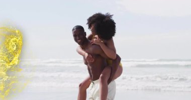 Adam kadını kıyıda taşırken altın fırıl fırıl fırıl yükselen ve seyahat reklamı için çifti saran adam. Romantizm, macera, tasasız, güneşli, canlı, birlik, neşe