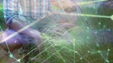 Ormanda çim biçen ve teftiş için filiz toplayan bir adam. Doğa, keşif, biyolojik çeşitlilik, yenilik, dijital bağlantı, keşif