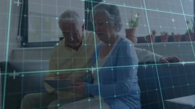 Kadın tableti tıklatıyor ve mavi şebeke örtüşmesini başlatıyor. Bu sırada yaşlı çift de teknik seçenekleri araştırıyor. Son sınıf, arkadaşlık, teknoloji, dijital, modern, rahatlama, etkileşim