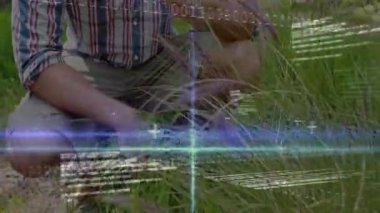 Adam açıklığa giriyor, çömelmiş uzun otları denetliyor, saatleri tıkırdatıyor, teknoloji taramayı örtüyor. Doğa, keşif, dijital, açık hava, macera, yenilik, bağlantı