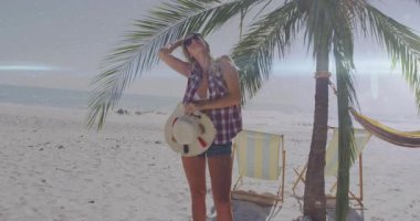 Bir kadının plaja palmiye ağacından girdiğini gösteren bir seyahat reklamı. Güneşin gölgelerini yapan, güneş gözlüğünü ayarlayan bir kadın. Sahil, boş zaman, tatil, tatil, dinlenme, açık hava, yaz