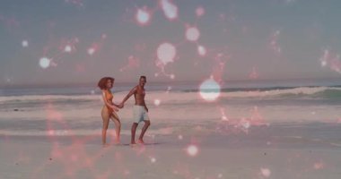 Çift sahile adım atıyor ve seyahat pazarlama için pembe bokeh örtüsüyle el ele yürüyor. Romantizm, tatil, rahatlık, huzur, sahil, uyum, yaşam tarzı