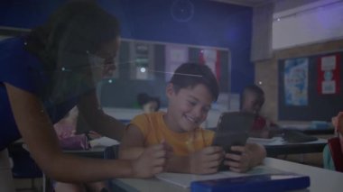 Eğitim için öğrencilere tablet tıklatıyor ve çevresine hareketli grafikleri aktifleştiriyor. Eğitim, teknoloji, sınıf, öğrenme, dijital, yenilik, danışmanlık