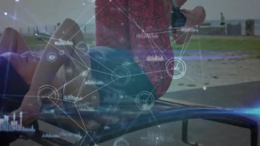 Kadın vücut çalışmasına başlıyor. Eğri karın kaslarındaki bükülmüş bacakları kaldırarak veri örtüsüyle güç toplamaya çalışıyor. Spor, sağlık, dijital arayüz, açık hava, güç, atletik, yenilik