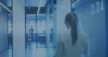 İş kadını cam salondan ofise doğru yürürken finans hologramlarının yüzdelerini analiz ediyor. Ofis, teknoloji, modern, işbirliği, analitik, yenilik, işyeri