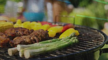 Açılış sahnesi, ızgara yakalama, duman yükselmesi, şiş çevirme, mısır ekleme, kömürleşme garantisi. Barbekü, açık hava yemekleri, yaz, ızgara, yemek hazırlama, bahçe, aşçılık.