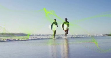 Sörf tahtalarını taşıyan ve güneşin altında spor yaparak kıyıya doğru koşan arkadaşlar. Plaj, macera, atletik, kıyı, doğa, aktif, yaşam tarzı