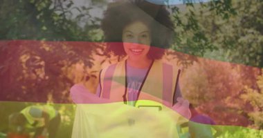 Gönüllü kadın çöp torbasının yerini değiştiriyor ve halk temizliğini bayrak animasyonuyla parka davet ediyor. Topluluk, çevrecilik, sürdürülebilirlik, takım çalışması, aktivizm, açık hava, sivil toplum