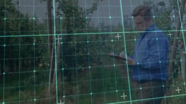 Tarım müfettişi panoyu alıyor ve verileri şebeke örtüsüyle yazarken meyveleri denetliyor. Meyve bahçesi, tarım, mahsul, teftiş, teknoloji, araştırma, veri