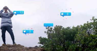 Yürüyüşçü, ufuk çizgisinin tepesinde dürbün kaldırıyor ve pazarlama için sosyal geri bildirim simgeleri gösteriyor. Macera, keşif, gözlem, manzara, çatışma, açık hava, engebeli