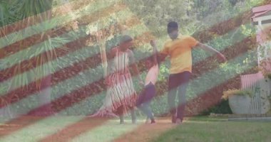 Ebeveynler çimenli arka bahçede yürümeye ve sağlığını ön plana çıkaran bir kız çocuğu sallamaya başladılar. Aile, açık hava, neşe, hareket, oyun, doğa, bağ.