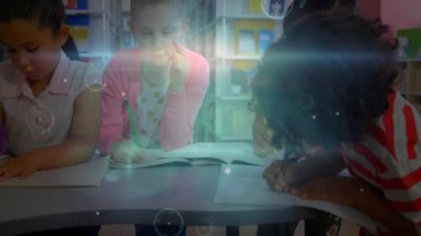 Kütüphane masasında yazan üç kız, parlayan küreler üretiyor, sahne boyunca dönen yörünge şemaları. Öğrenciler, eğitim, yaratıcılık, odaklanma, yenilik, işbirliği, öğrenme