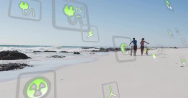 Sahilde yüzen yeşil enerji ikonları, sürdürülebilir enerjiyi keşfeden bisikletleri iten çiftler. Sürdürülebilirlik, çevre dostu, koruma, yenilenebilir, açık hava, yaşam tarzı, canlı