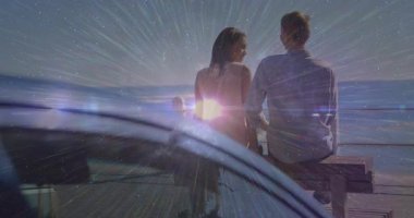 Rıhtımdaki yolcu koltuğunda oturan sinematik çifte binen araba patlayan bir işaret fişeği gibi paylaşıyor. Romantik, günbatımı, siluet, sahil, boş zaman, canlı, atmosferik