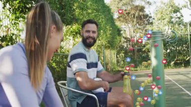 Erkek ve bayan sporcular spor susuzluğu molasında kıkırdaşıyor, emojiler kenarda yüzüyor. Açık hava, eğlence, eğlence, arkadaşlık, sağIık, hayat dolu, enerjik.