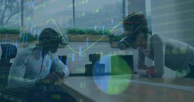 İş arkadaşları VR kulaklıkları takıyor ve masa başında el kol hareketi yaparak sanal finans grafiklerini keşfediyorlar. İşbirliği, teknoloji, yenilik, gelecek, takım çalışması, dijital, kurumsal